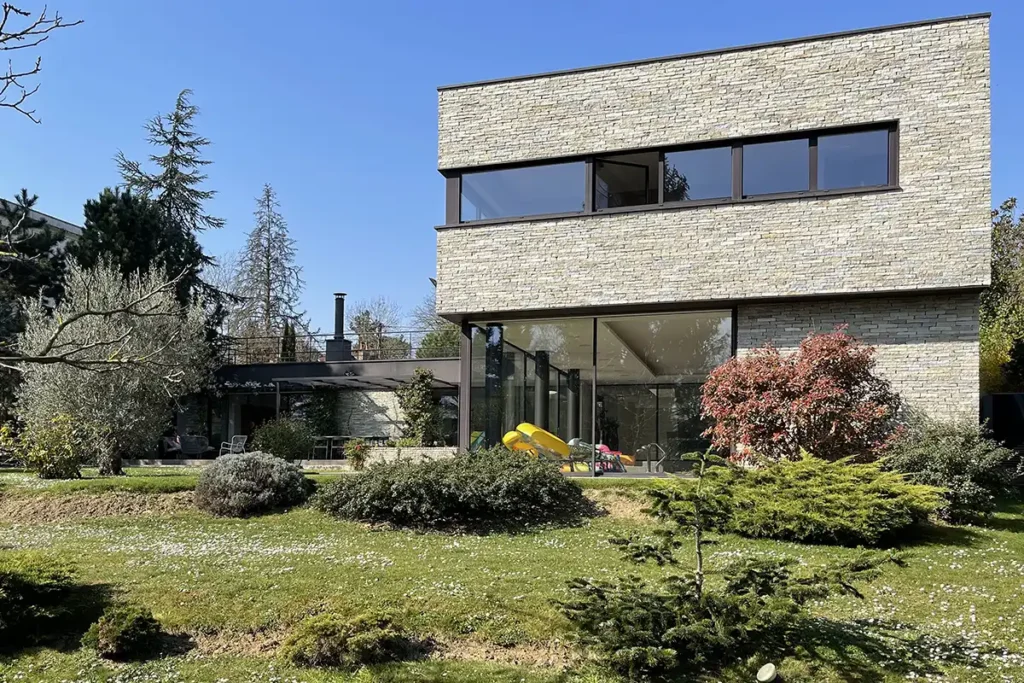 maison d'architecte avec façade en pierre sur un terrain en pente