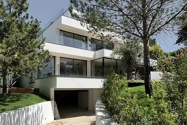 Villa moderne: photo côté sud-ouest, en contrebas, avec vue sur la rampe d'accès au sous-sol