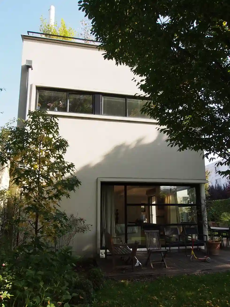 Maison individuelle architecte : façade ouest. On voit la baie atelier (baie d'angle) au rez-de-chaussée et la baie ruban , façon Le Corbusier, à l'étage